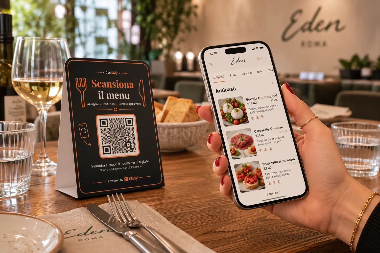 Il menu digitale Tàvly aperto sul telefono, accanto al display con il QR code sul tavolo di un ristorante